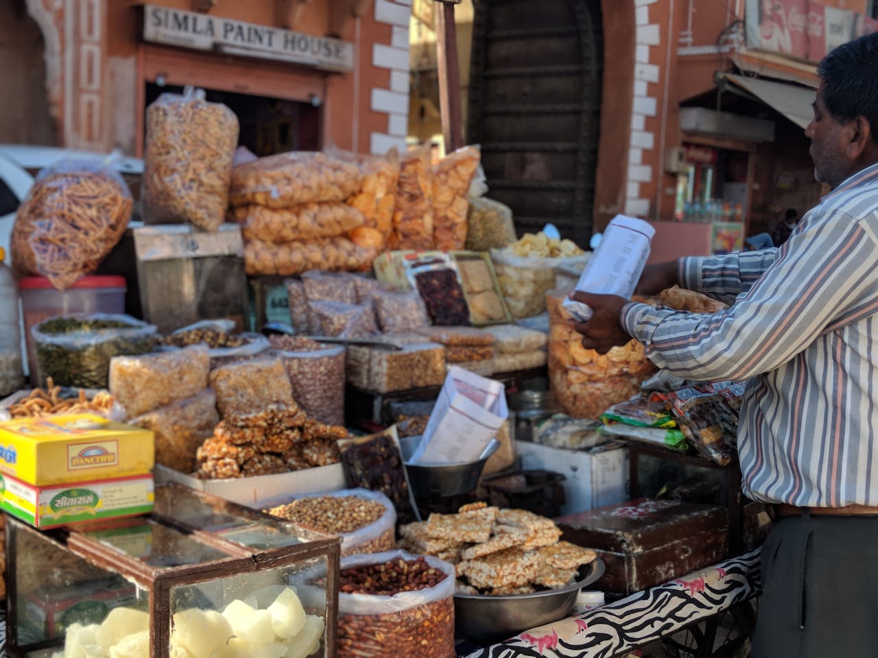 A bustling street food stall in Jaipur, showcasing a variety of traditional Indian snacks and a merchant.