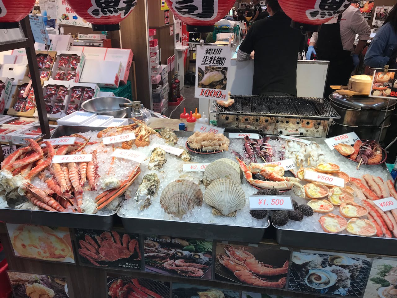 Fresh seafood displayed at a vibrant Osaka market stall, showcasing a variety of delicacies.